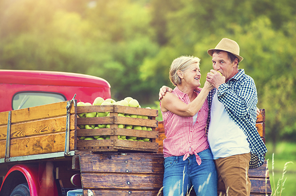 Senior couple by truck after harvesting apples