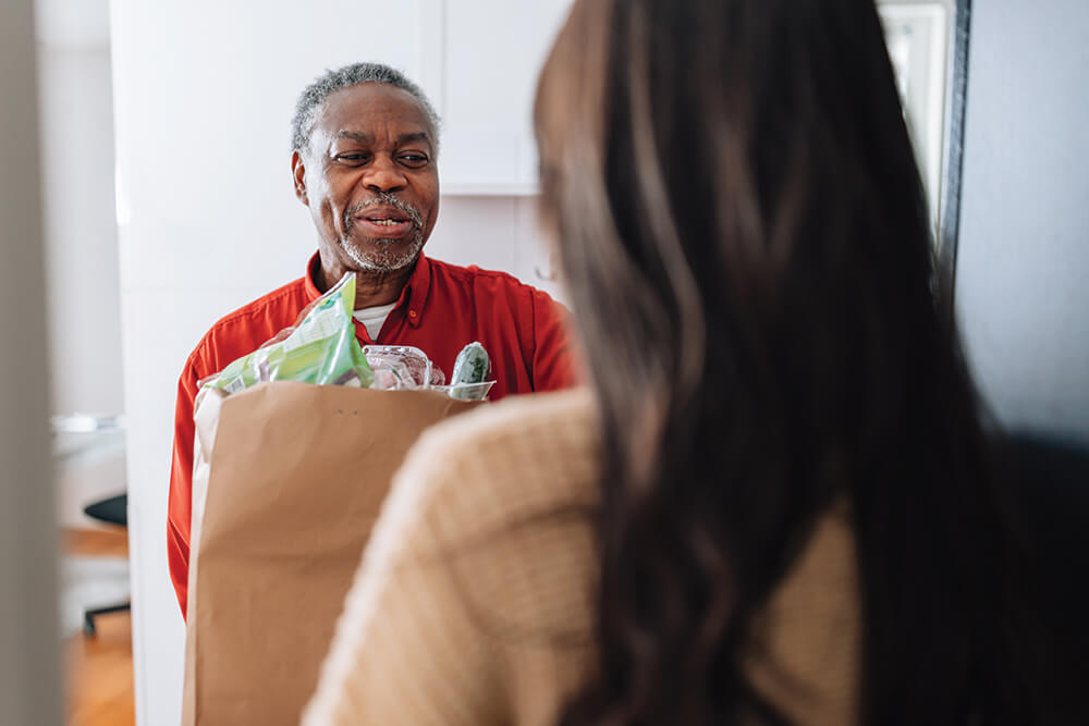 A man delivers a bag of groceries.