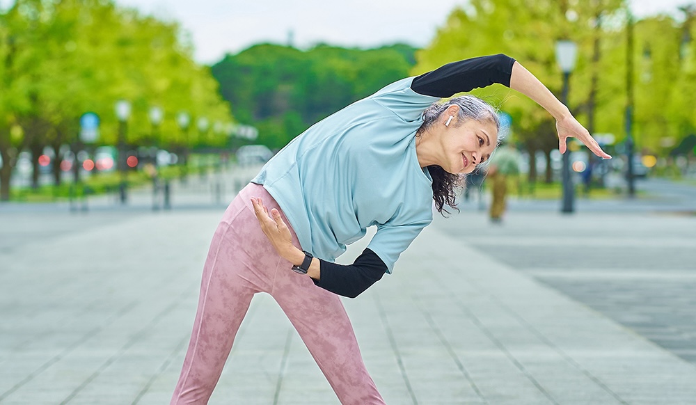 A woman stretches in a a park.